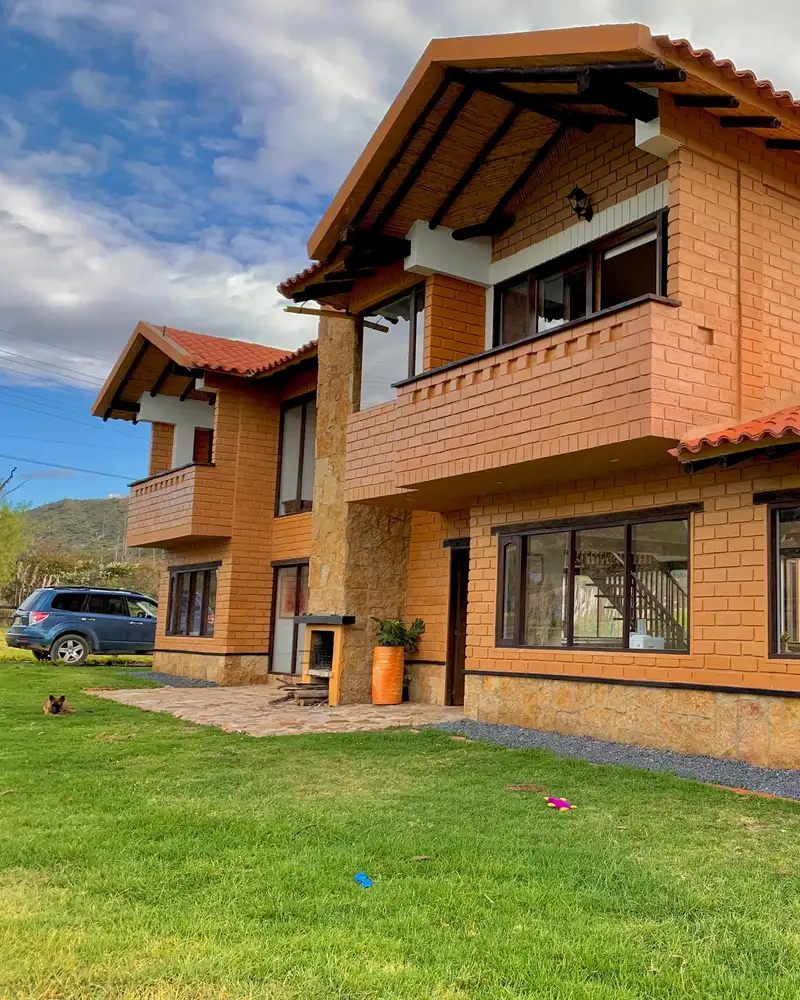 Casa del Lago, obra del Arq. Iván Prieto: fachada de dos pisos en bloque de tierra comprimida con cubierta de teja de barro, en la vereda Ritoque de Villa de Leyva