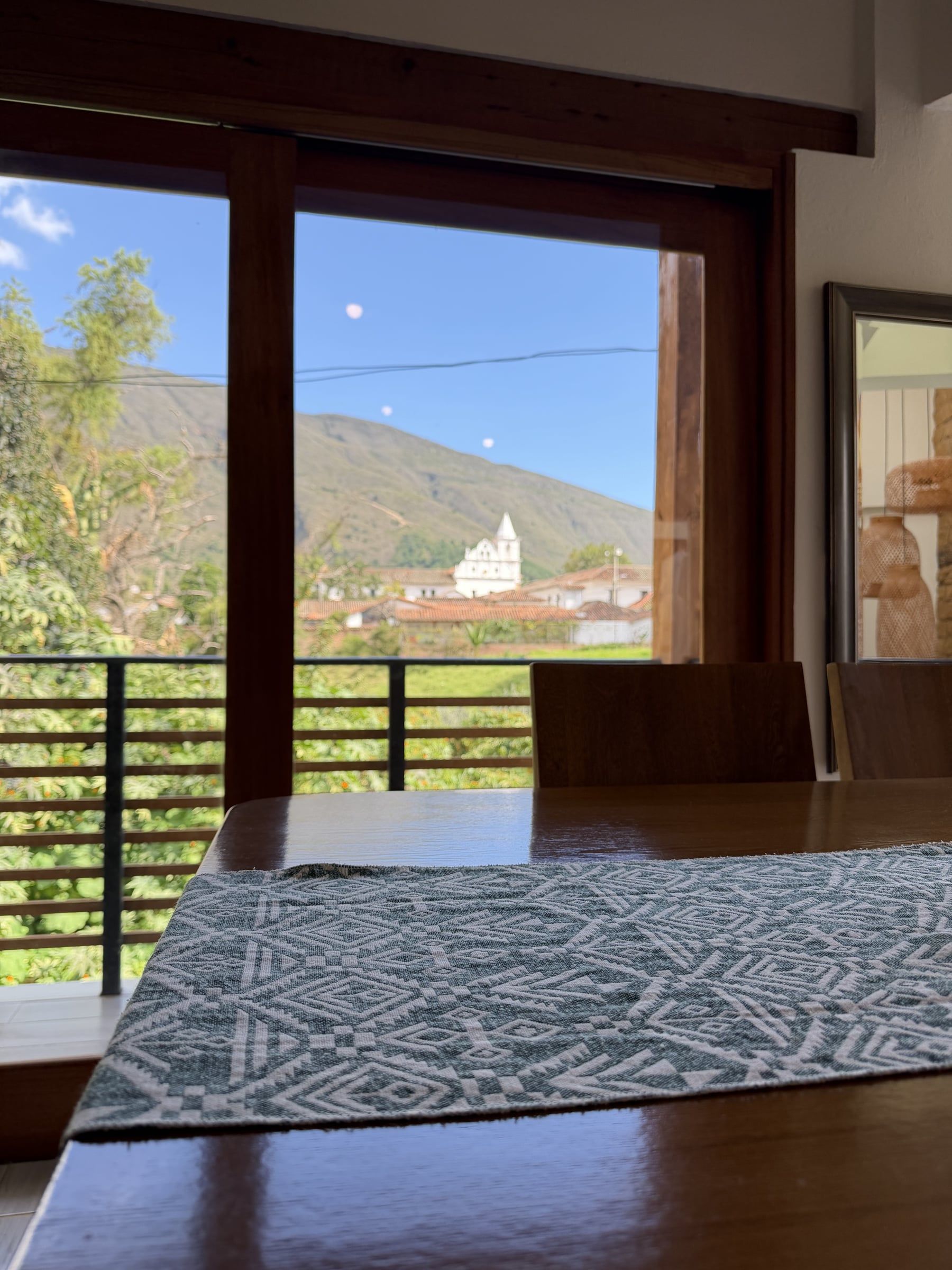 Ventana de la Casa Juan con vista a los cerros y a una iglesia del centro histórico de Villa de Leyva