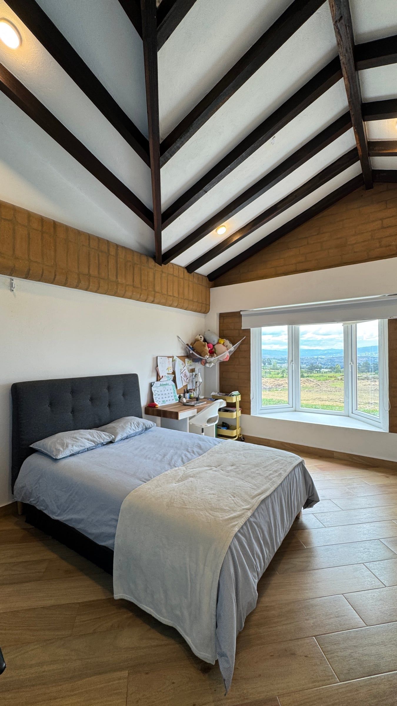 Habitación con muro de tierra a la vista y ventana hacia el paisaje